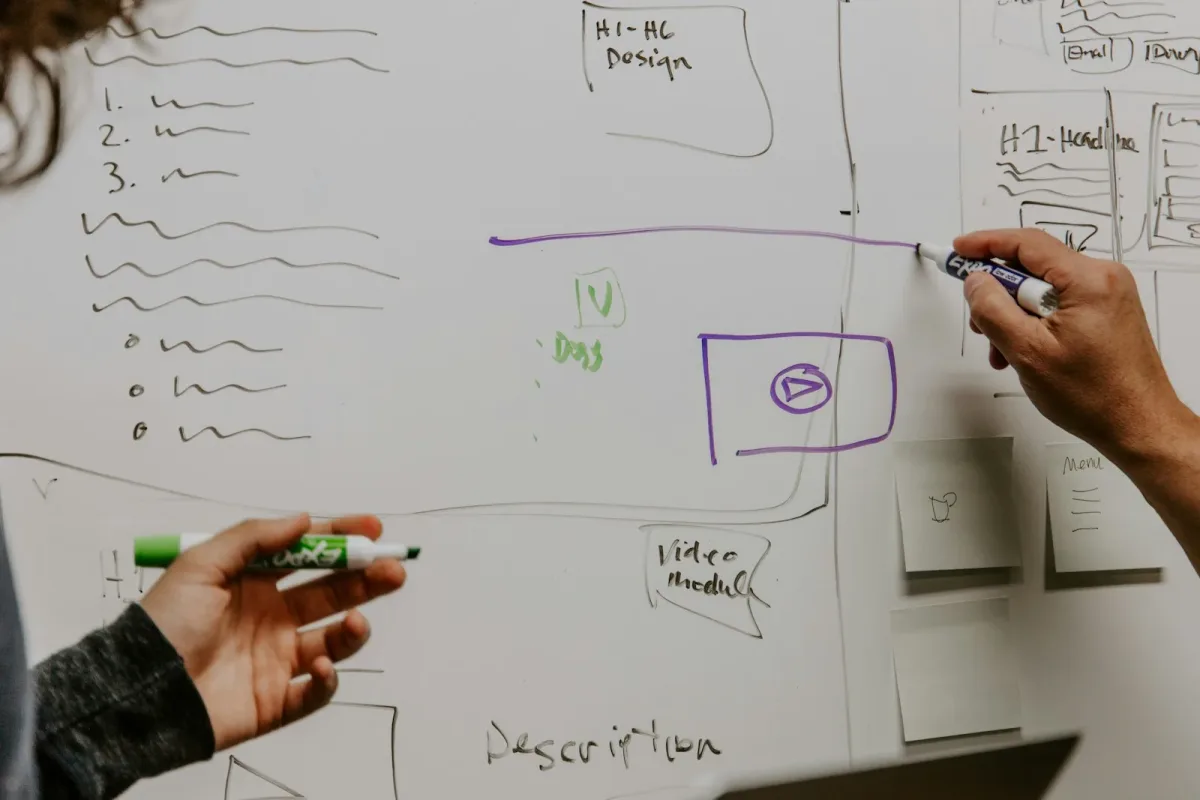 Dos personas revisando ideas en una pizarra durante un proceso de rebranding