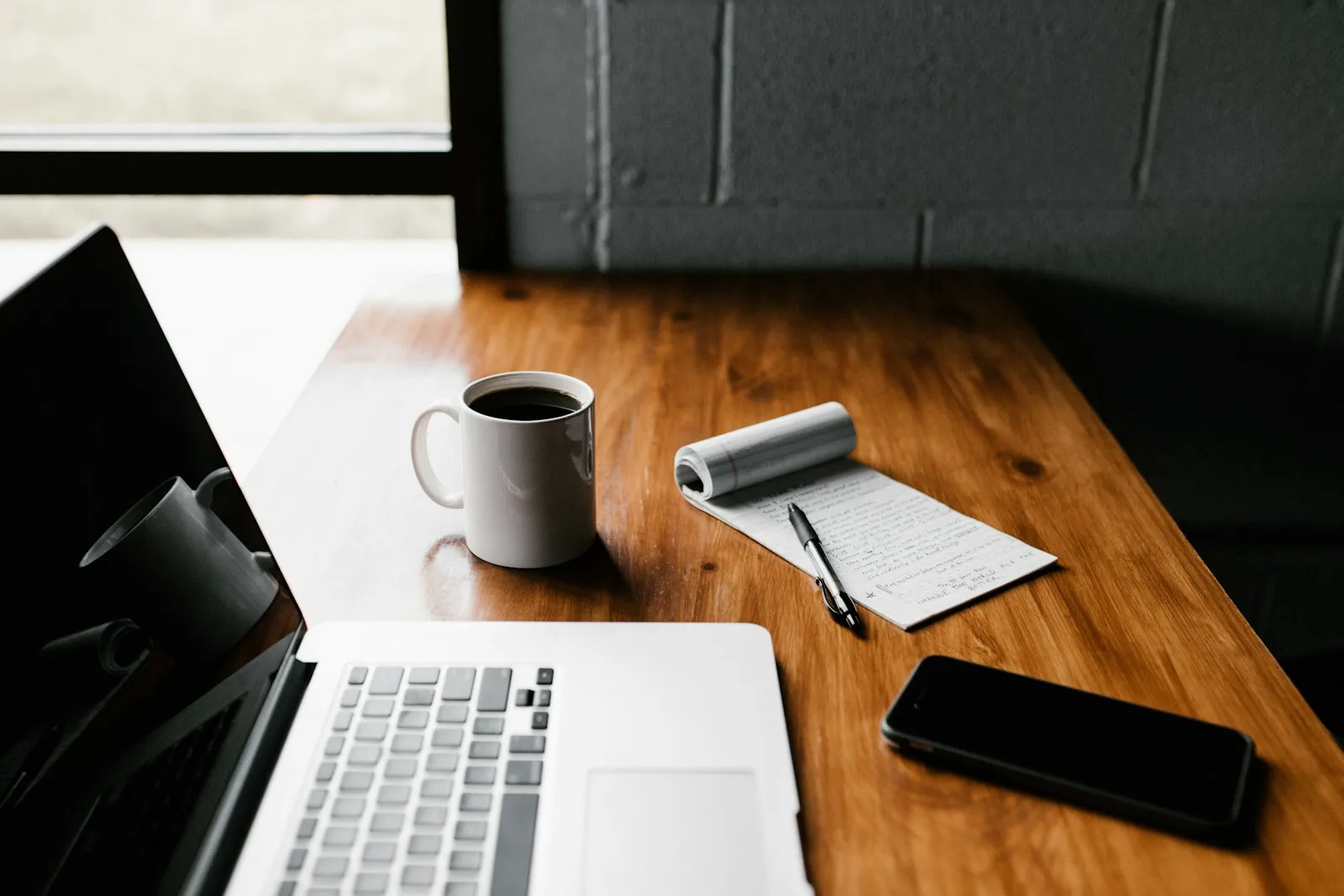 Ordenador, teléfono y cuaderno como conjunto de herramientas digitales de trabajo